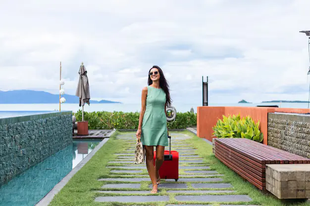 happy caucasian pretty long hair elegant tourist woman dress with red suitcase outside hotel 343596 3664